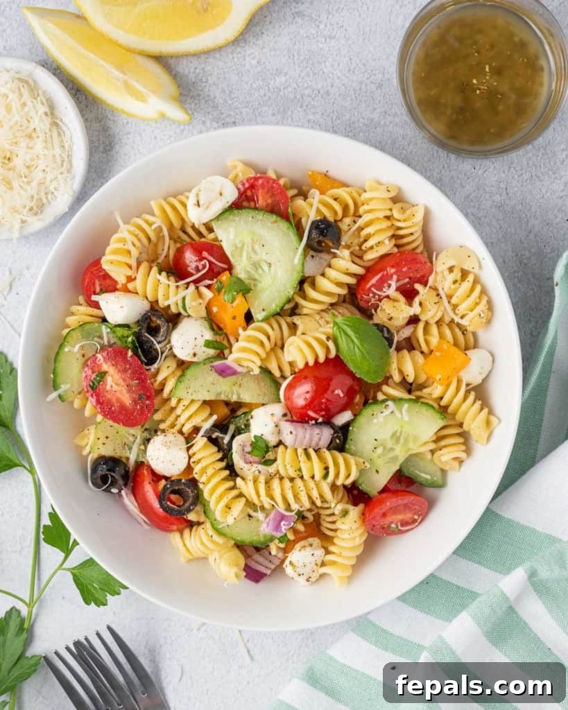 Zesty Italian Pasta Salad 12 A round white plate filled with colorful Italian pasta salad, showcasing its fresh and appetizing appeal.