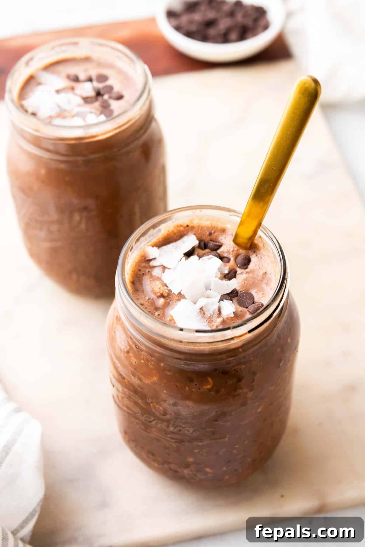 Two jars of overnight oats with chocolate chips and coconut flakes as toppings
