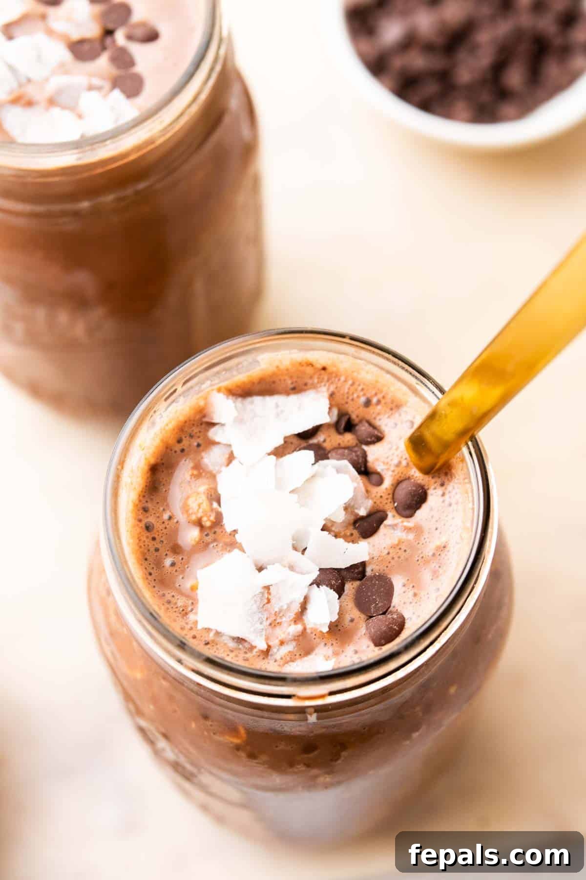 One jar of chocolate peanut butter overnight oats with a spoon and garnished with coconut flakes on top