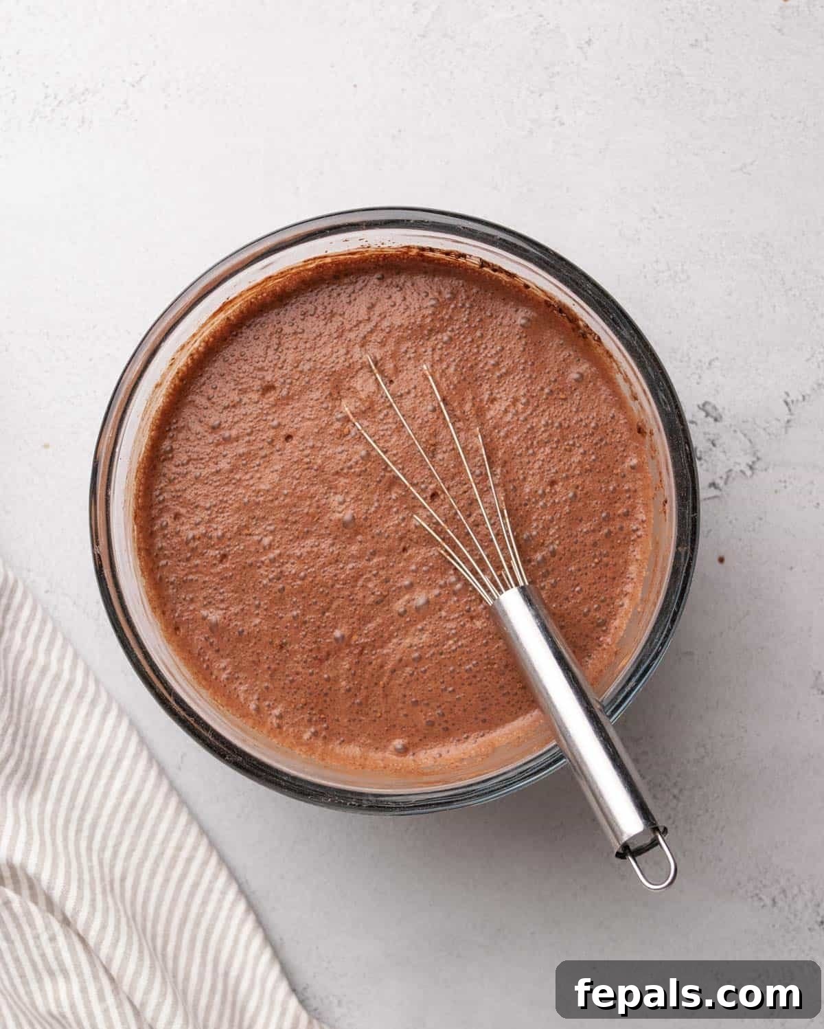 chia seed and cocoa powder mixed in with the milk n a clear bowl