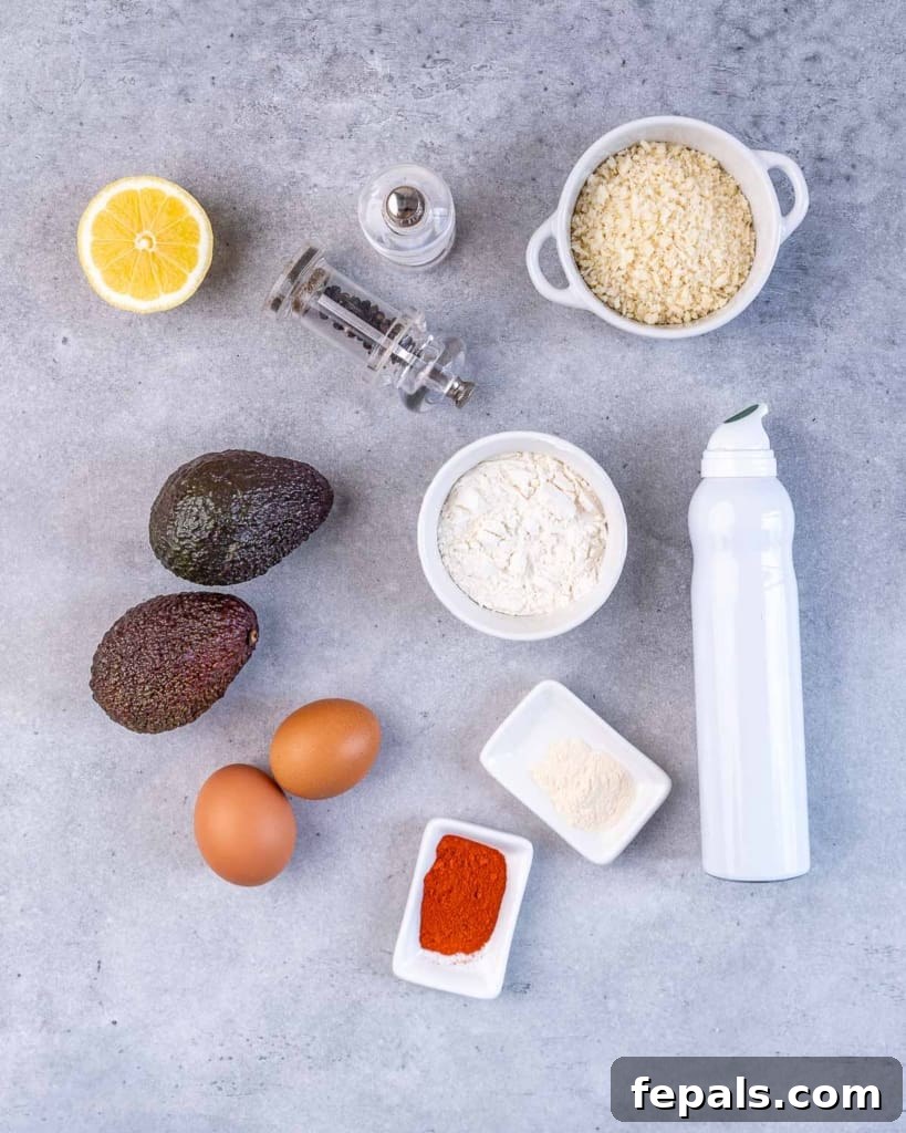 Avocado Golden Fingers 4 Ingredients for baked avocado fries laid out on a grey table: avocados, lemons, spices, flour, eggs, breadcrumbs