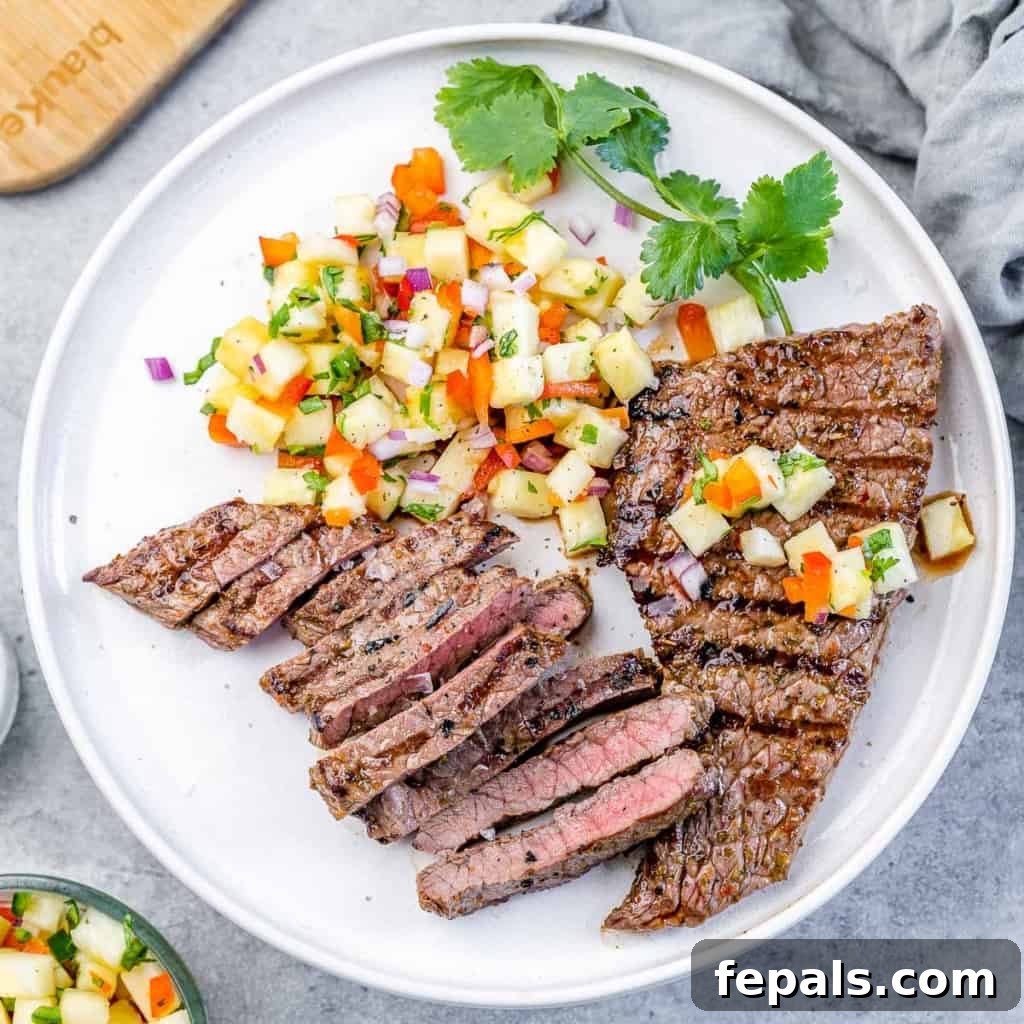 Grilled Steak with Tropical Pineapple Salsa 3 top view image of two steaks on a white plate with pineapple salsa