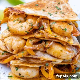 front view of shrimp quesadillas with parsley and lime wedges