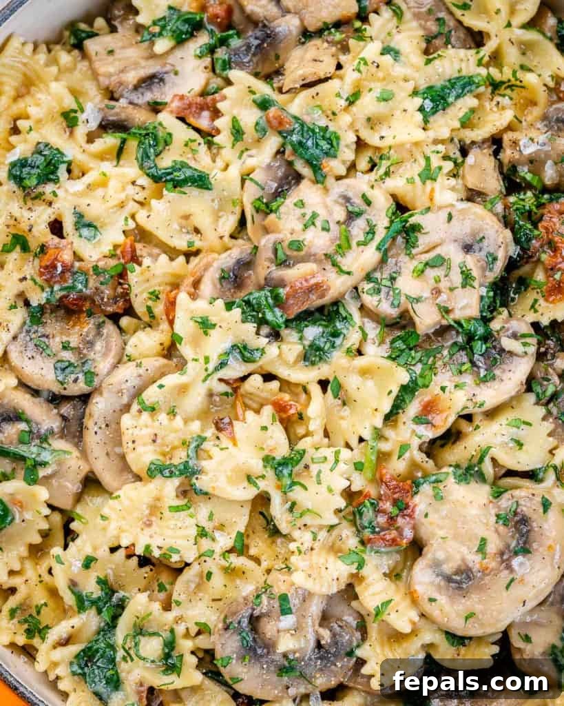 close up mushroom and spinach pasta, showcasing the creamy sauce and vibrant ingredients