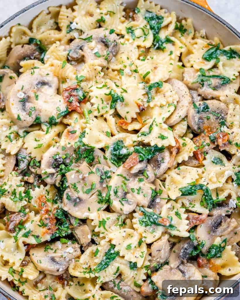 close up mushroom pasta in a pan, steaming hot and ready to serve