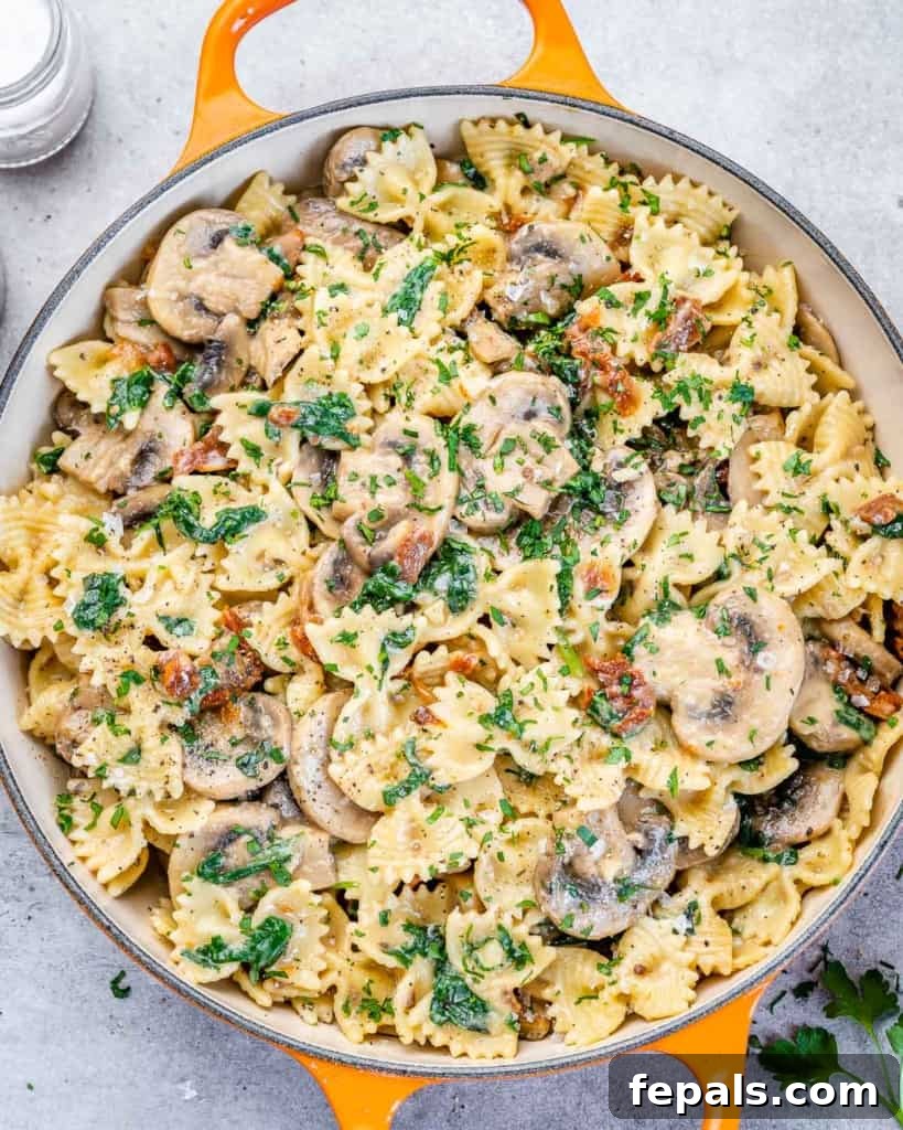 top view mushroom pasta in an orange skillet, beautifully plated
