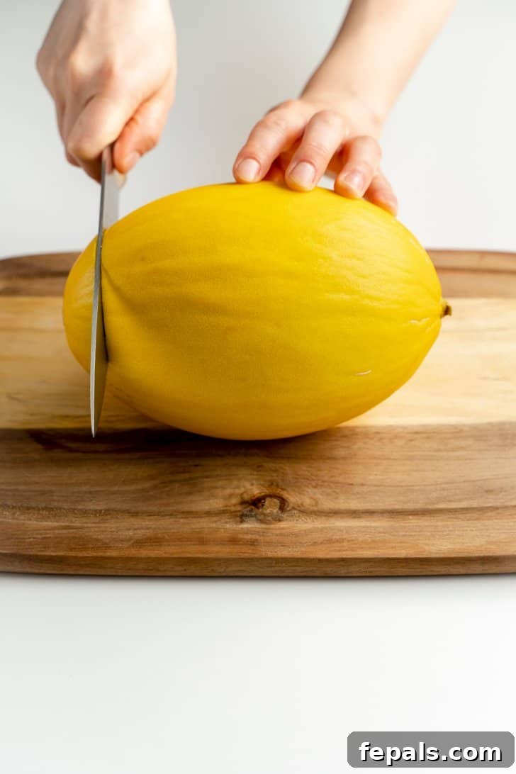 cutting the end off a cantaloupe with a knife