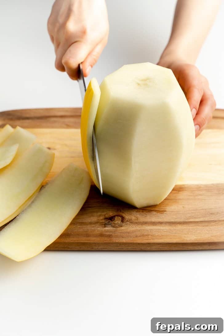 slicing the skin off the cantaloupe with a knife