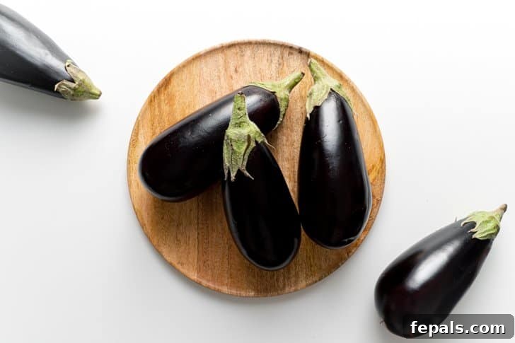 Selecting the Best Eggplant for Your Recipes Five vibrant purple eggplants resting on a kitchen surface, highlighting their fresh appearance.