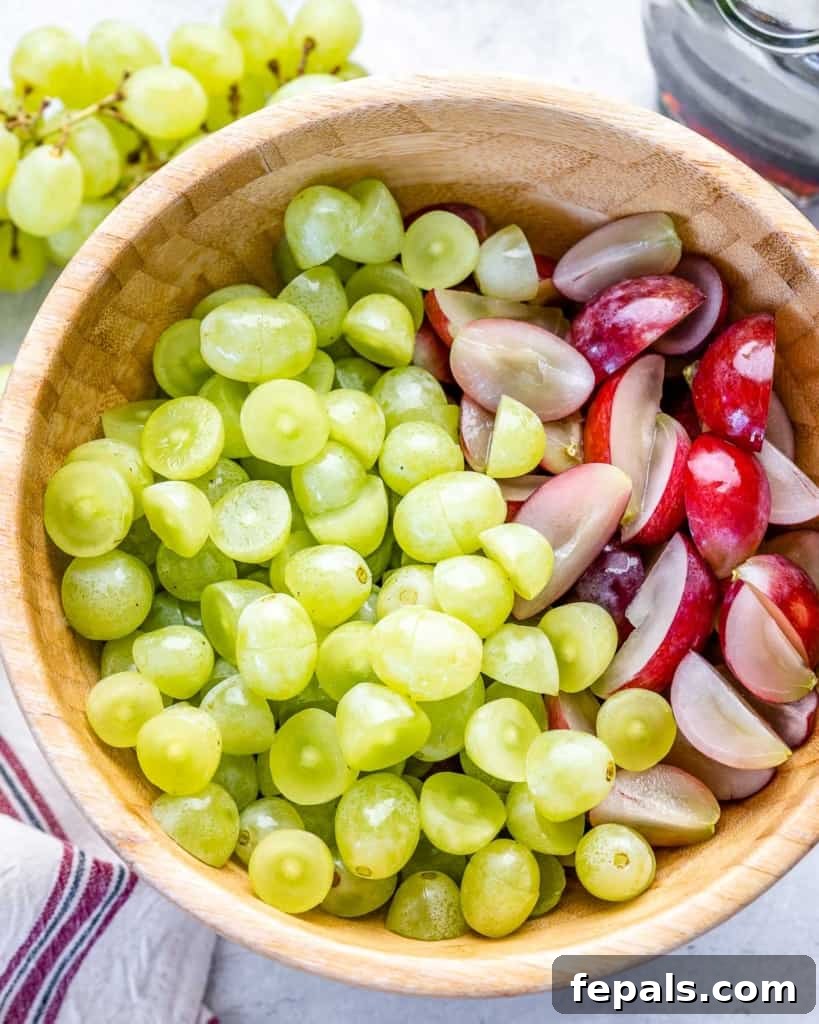 Freshly sliced grapes in a rustic wooden bowl, ready to be mixed with the creamy dressing.