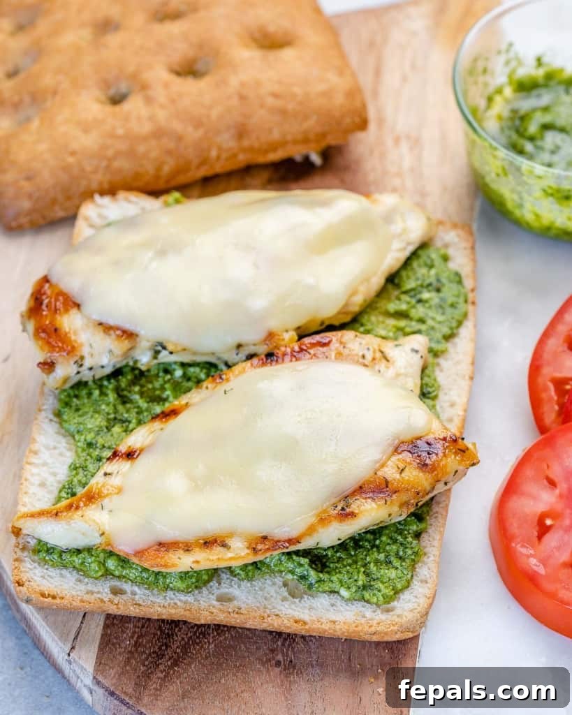 Gourmet Grilled Chicken Sandwich 6 Cheese melting on chicken in an open sandwich.