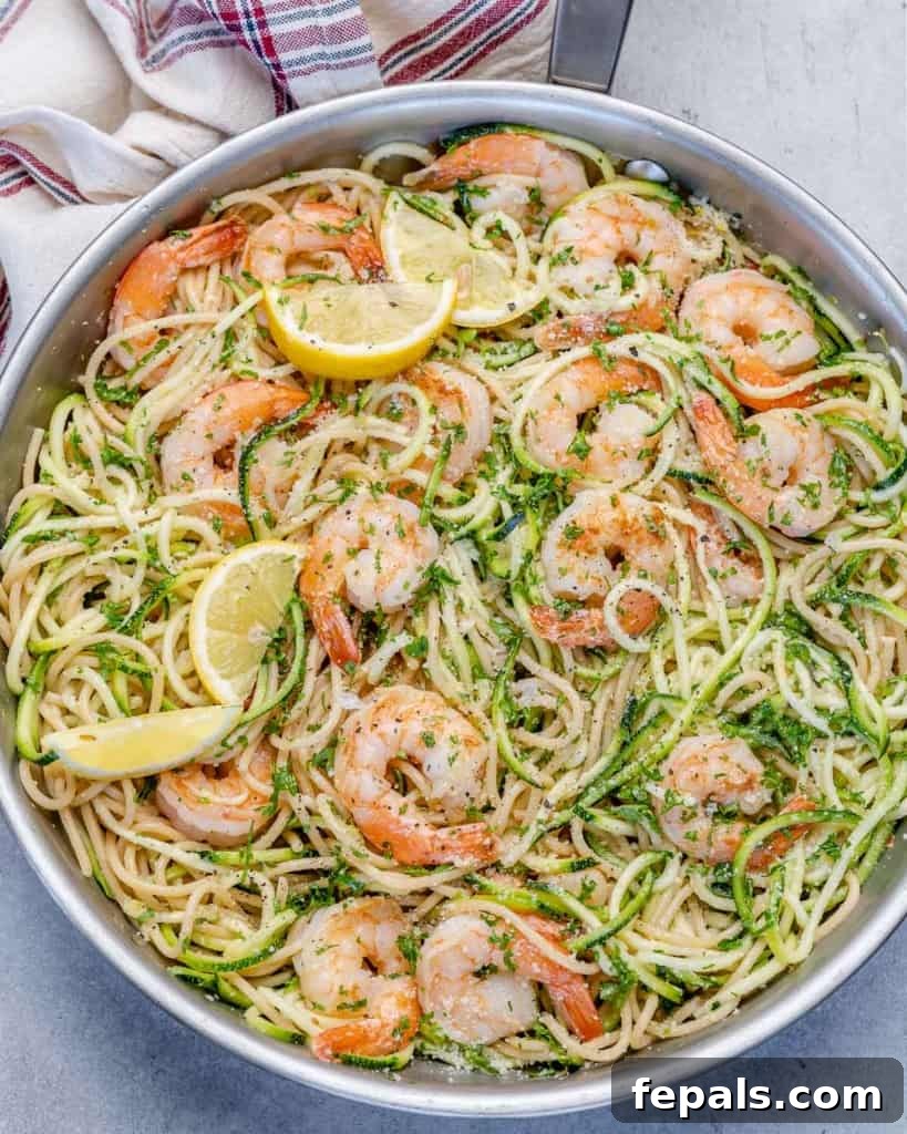 Zesty Lemon Shrimp Pasta with Zucchini Noodles 7 A large skillet brimming with freshly combined lemon garlic shrimp pasta and zucchini noodles, glistening with sauce.
