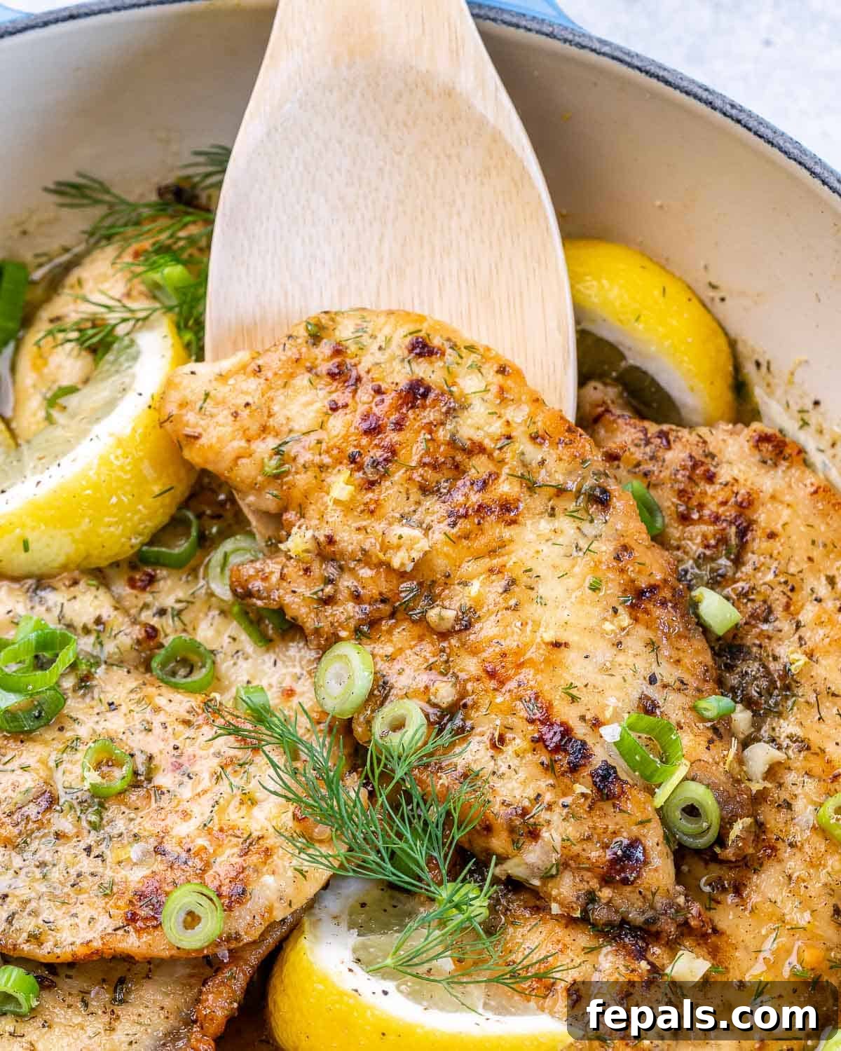 Easy Lemon Chicken Breast Recipe skillet with lemon chicken breasts and lemon wedges