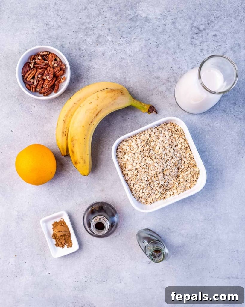 No-Bake Banana Bread Oats 4 A beautifully composed flat lay photograph showcasing all the fresh, wholesome ingredients required for banana bread overnight oats: two perfectly ripe bananas, a jug of creamy milk, a bowl of hearty rolled oats, a bottle of vanilla extract, a generous pour of maple syrup, a sprinkle of ground cinnamon, a vibrant orange ready for zesting, and a small bowl of crunchy chopped pecans.