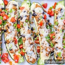 Delicious stuffed zucchini boats with melted cheese and chopped tomatoes.