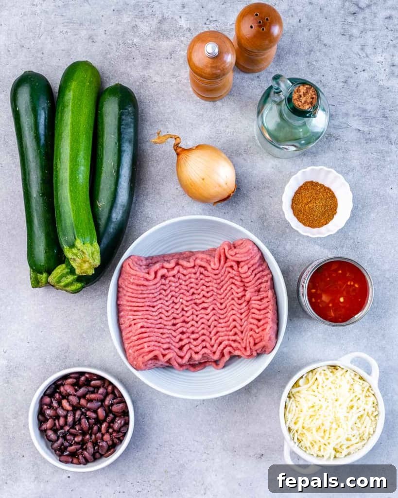 A vibrant selection of fresh ingredients neatly arranged on a grey table, ready for preparing Zucchini Taco Boats.