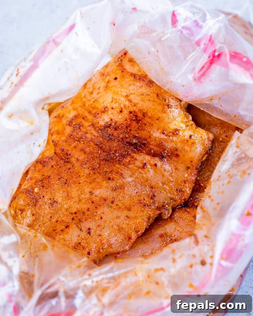 Golden Chicken with Fiesta Rice Core 5 A hand placing chicken breast and marinade ingredients into a clear ziplock bag.