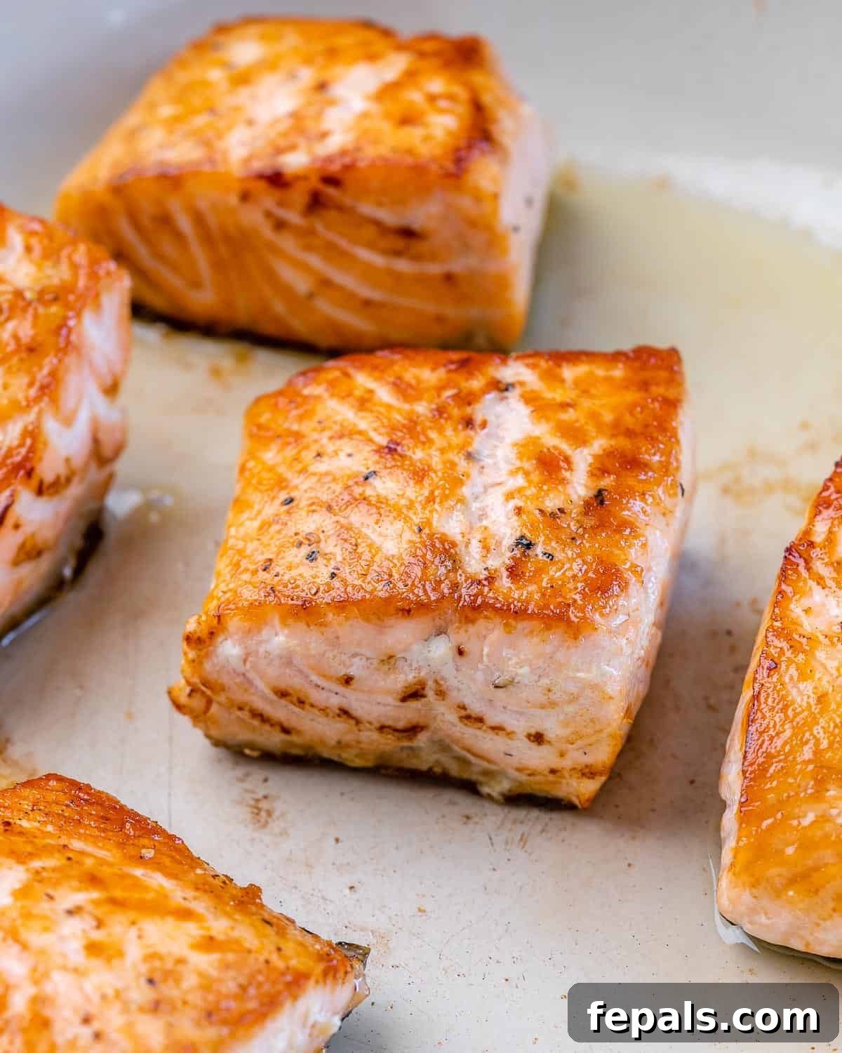 Fresh salmon fillets seasoned with salt and pepper, ready to be cooked in a hot skillet.