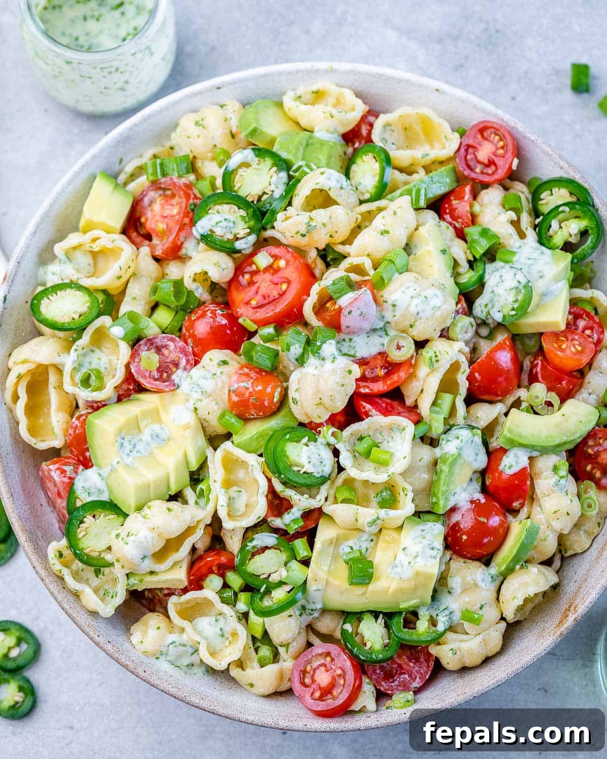 cilantro lime pasta salad in one bowl with dressing