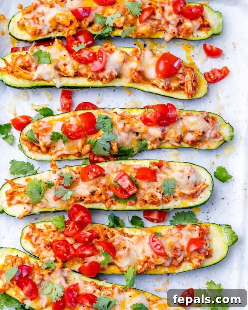 Zucchini Enchilada Bake 2 Two zucchini halves generously filled with chicken and cheese, ready for baking.