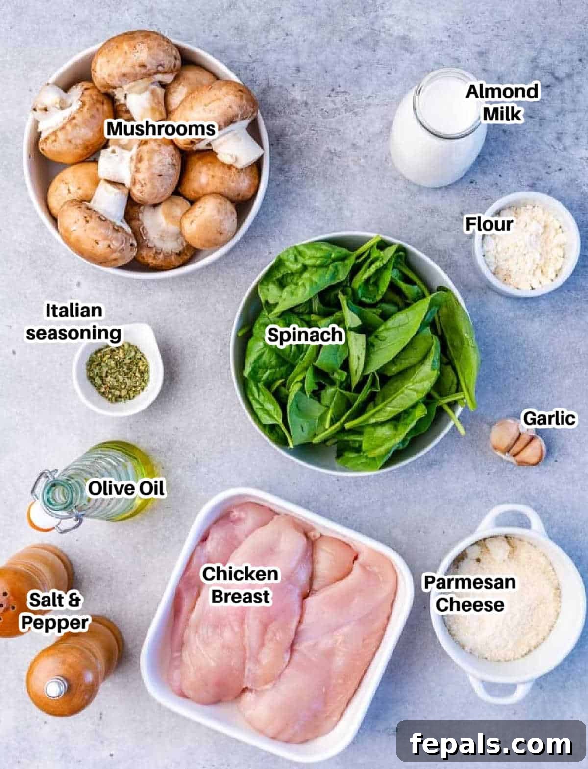 Ingredients laid out on a table to make creamy spinach and parmesan chicken skillet.
