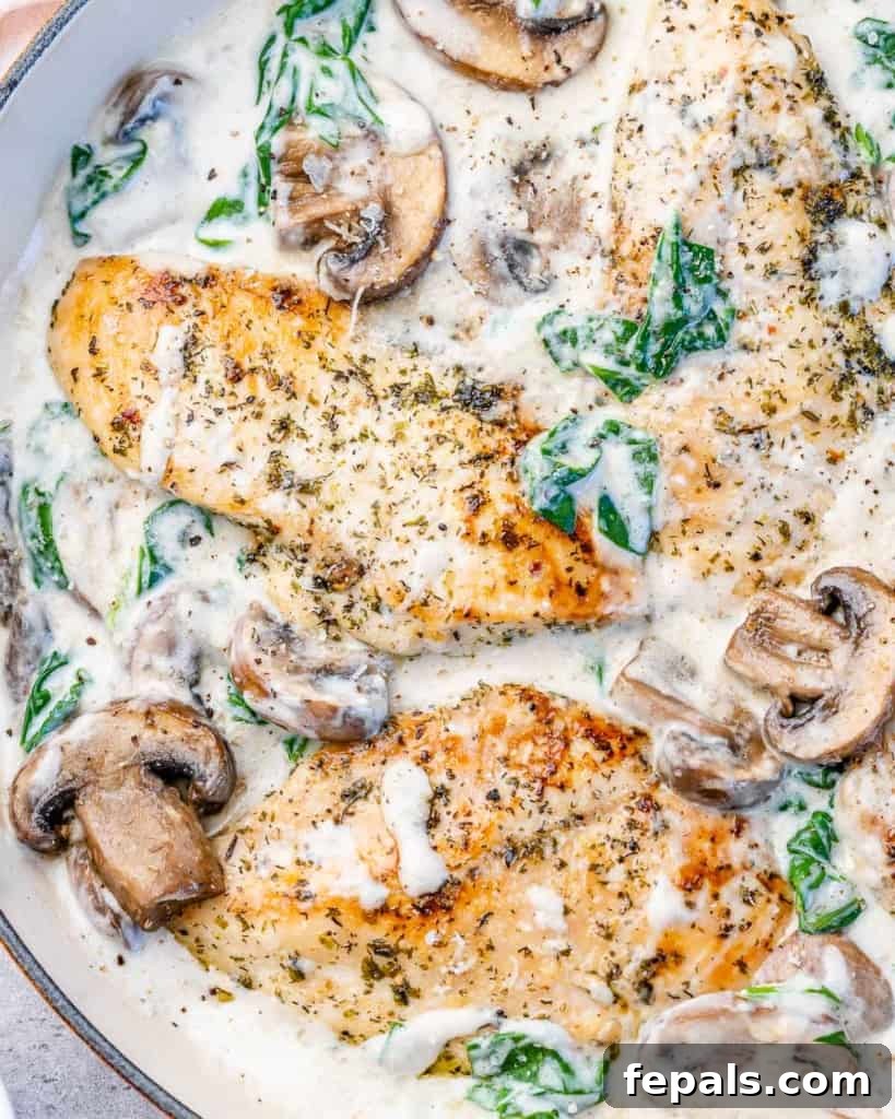 Top view of creamy chicken with spinach in a skillet, ready to serve.