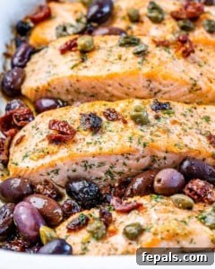 close up of baked salmon with kalamata olives and capers