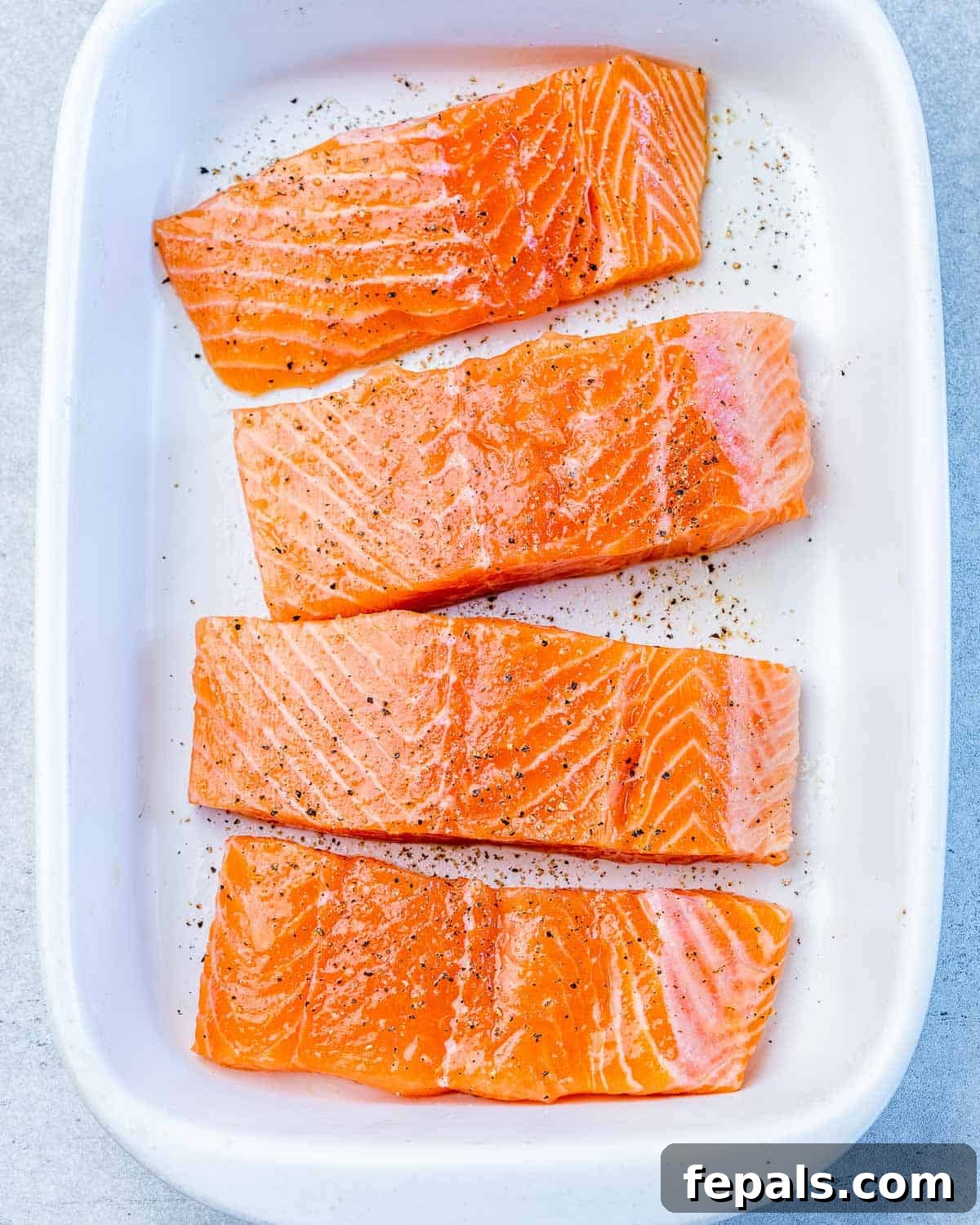 Raw salmon seasoned with salt and pepper.