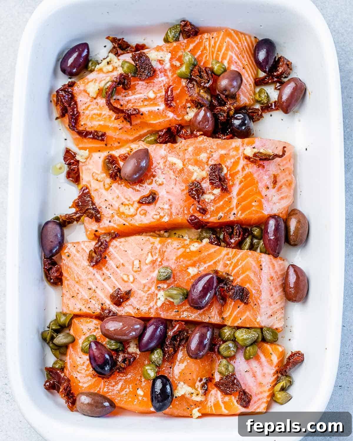 Salmon filets topped with olives and capers.