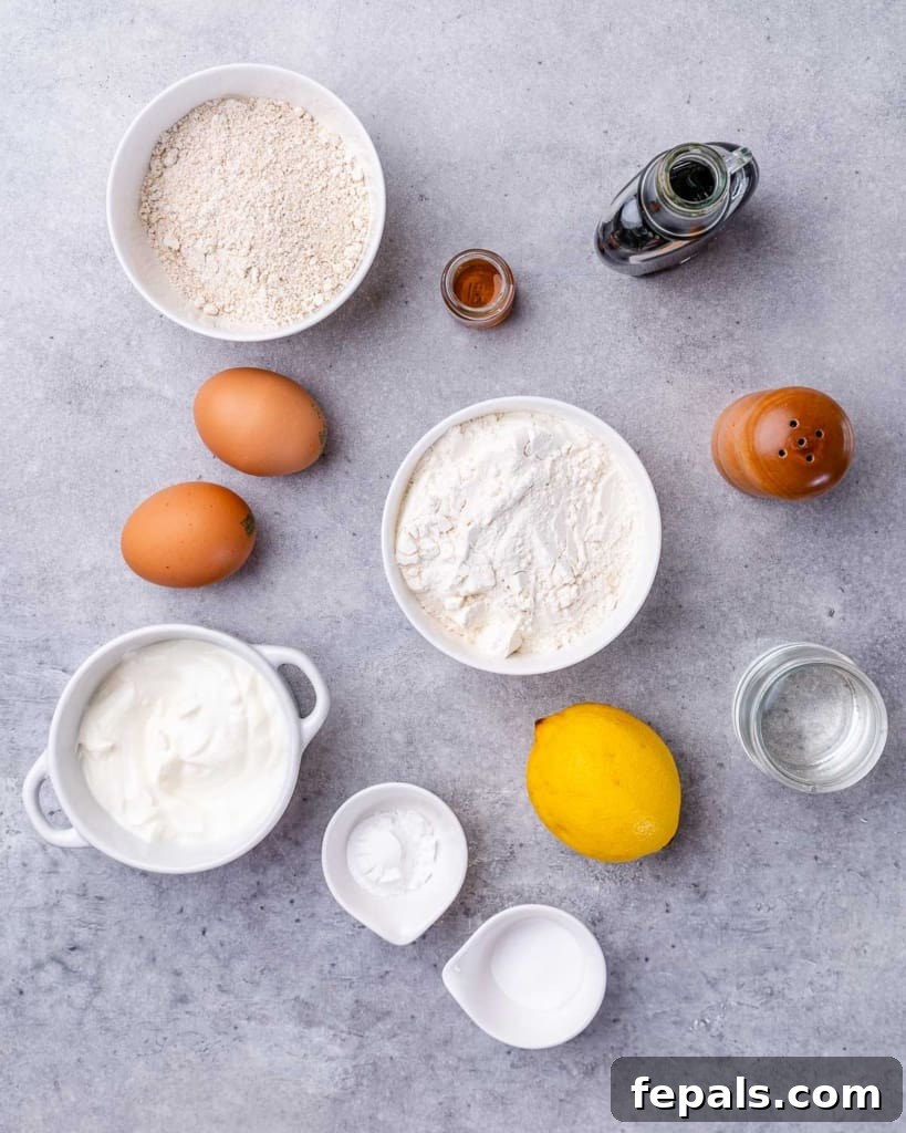 Bread ingredients divided into small bowls near eggs and a lemon.