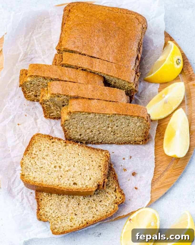 top view of lemon bread slices with fresh lemon slices on the right side of the loaf bread