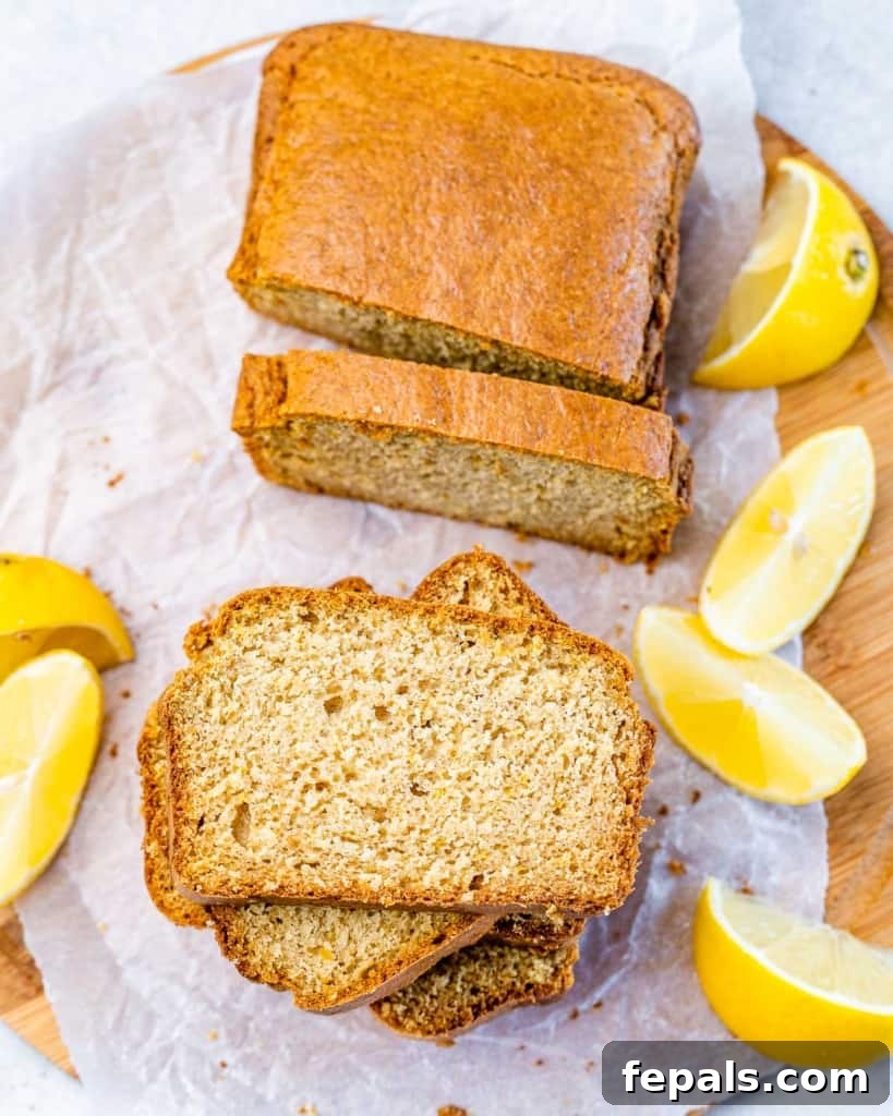 Sliced healthy lemon loaf near lemon wedges.