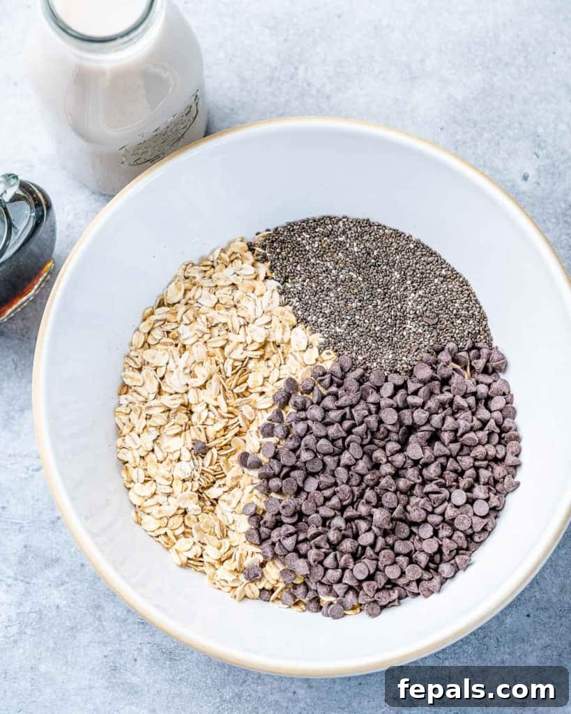 Guilt-Free Cookie Dough Oats 5 Kuru yulaf karışımına badem ezmesi dökülüyor.