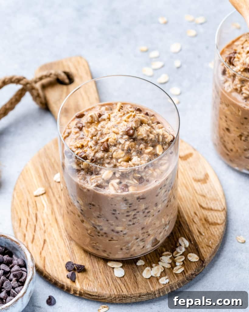 Guilt-Free Cookie Dough Oats 10 Kurabiye hamuru geceden kalma yulaf dolu bir kavanozun üzerine bolca mini çikolata parçacıkları eklenmiş, görsel çekiciliğini artırıyor.