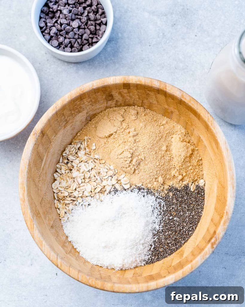 Making Chunky Monkey Overnight Oats in a wooden bowl, showing dry ingredients being combined.