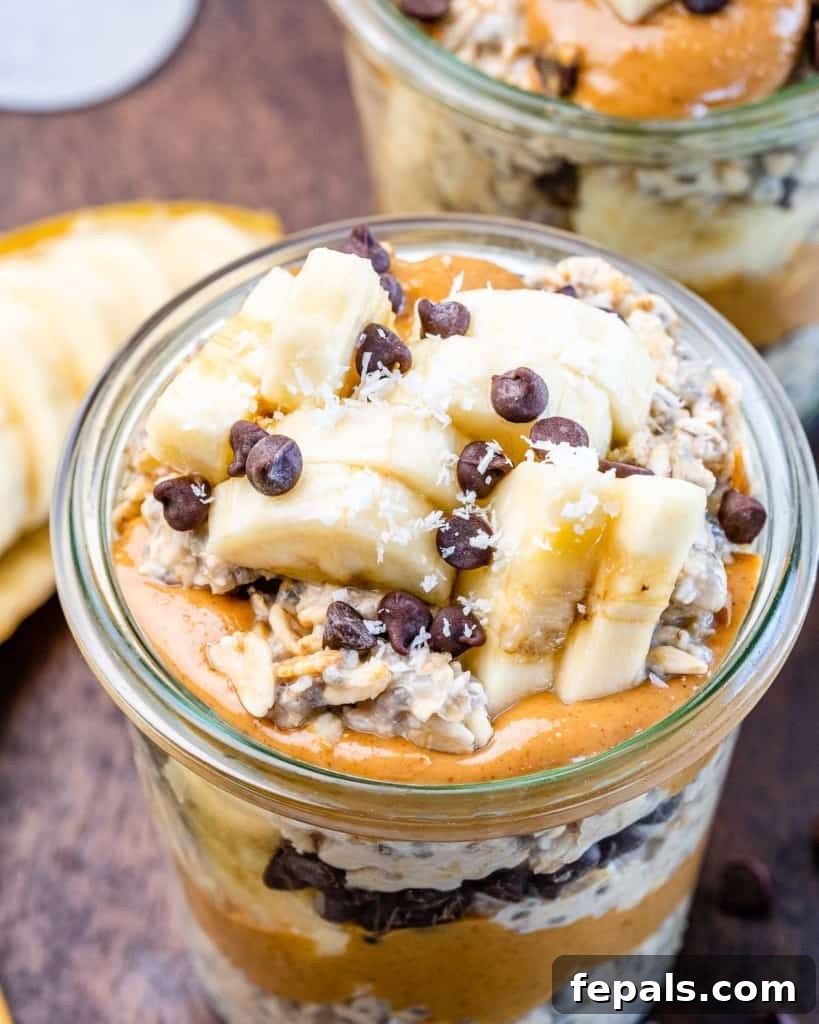 A close-up shot of Chunky Monkey Overnight Oats, rich with bananas, peanut butter, coconut, and chocolate chips.
