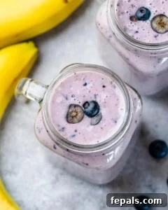 A perfectly blended blueberry banana smoothie in a glass mason jar.