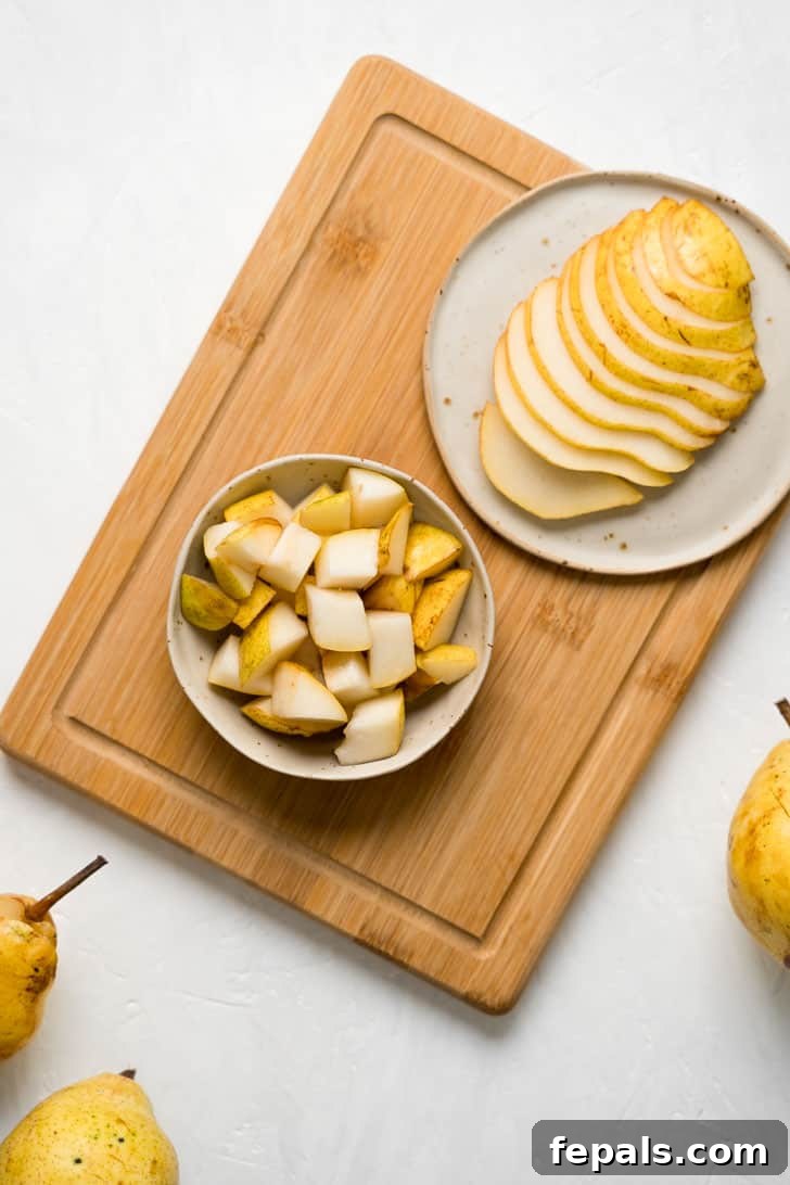 How to Cut a Pear A vibrant composition featuring a bowl brimming with cubed pears, artfully placed beside a plate of neatly sliced pears, all resting on a wooden board.