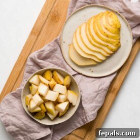 one plate of sliced pear next to a bowl of pear cubes with napkin and cutting board