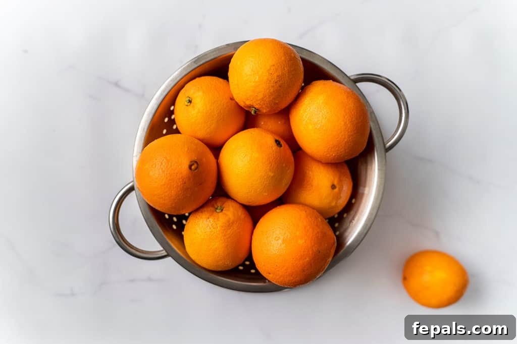 A bowl filled with fresh, whole oranges, vibrant and ready for peeling and slicing.