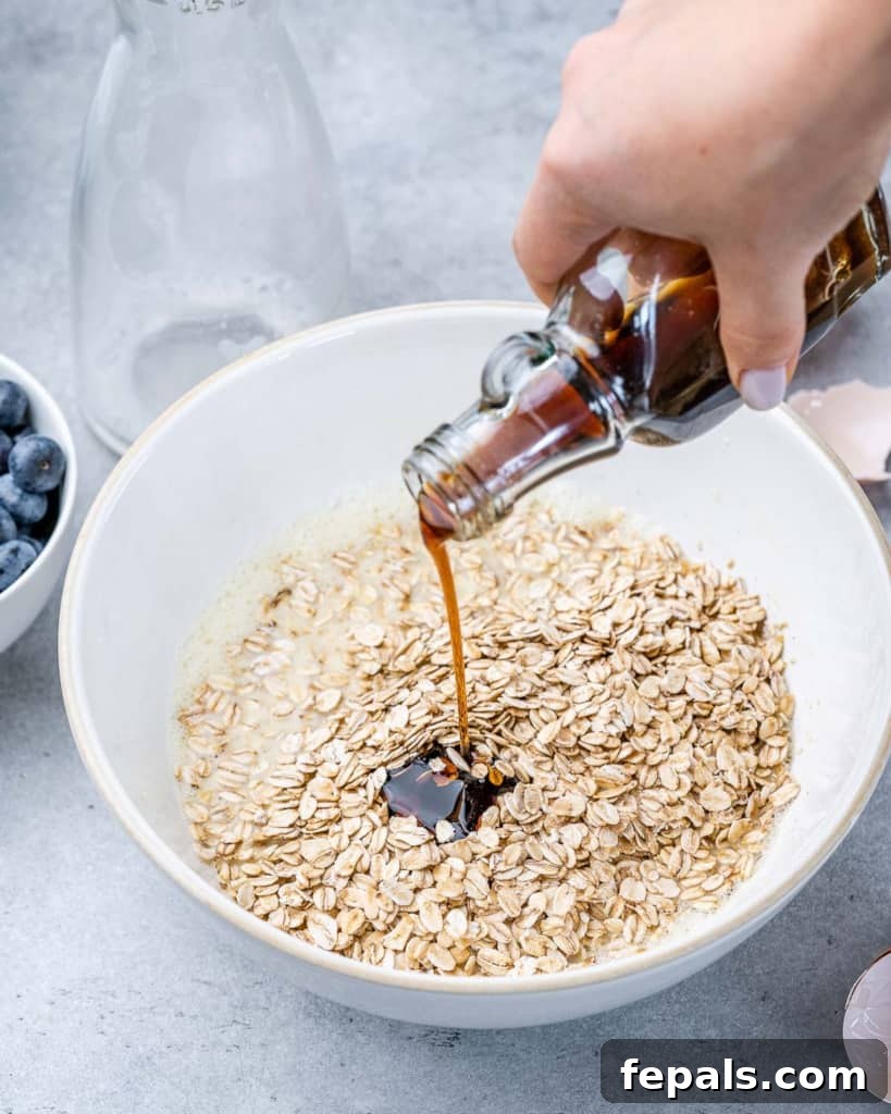 Pouring vanilla into a bowl of oats.