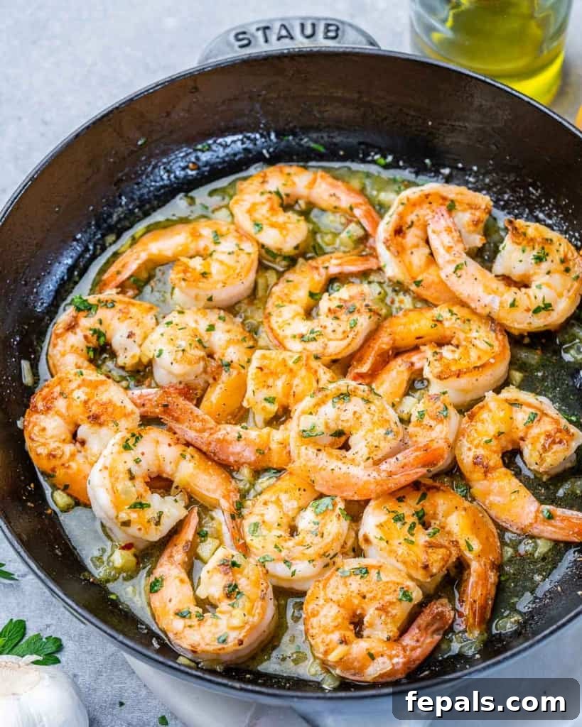 Guilt-Free Garlic Shrimp Scampi 7 side shot of sauteed shrimp on a black skillet, perfectly cooked