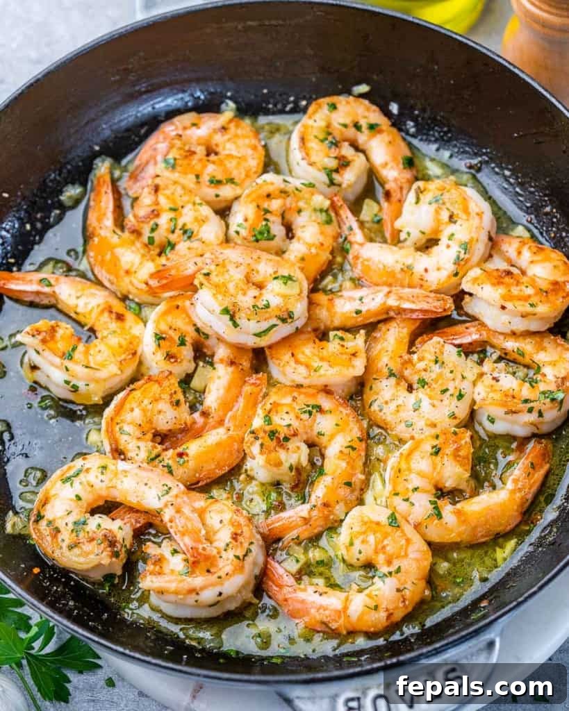 Guilt-Free Garlic Shrimp Scampi 8 top view shrimp cooked in a black skillet with lemon and parsley garnish