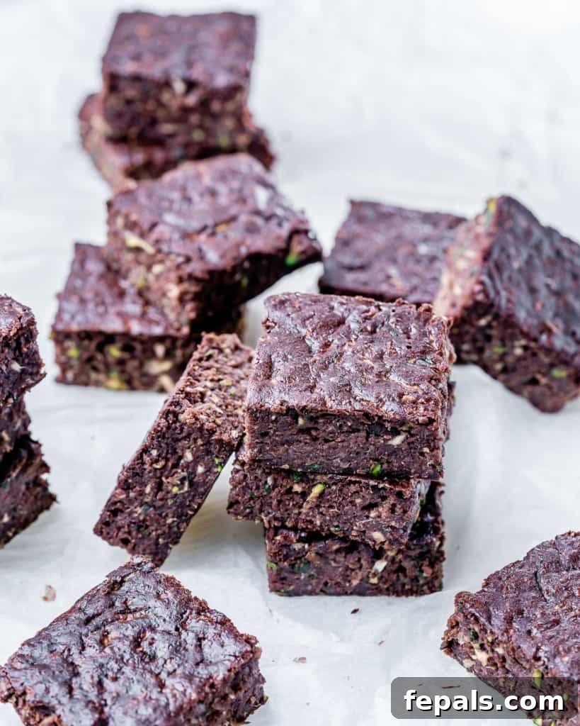 A side view of stacked healthy zucchini brownie squares, highlighting their moist, dense texture.
