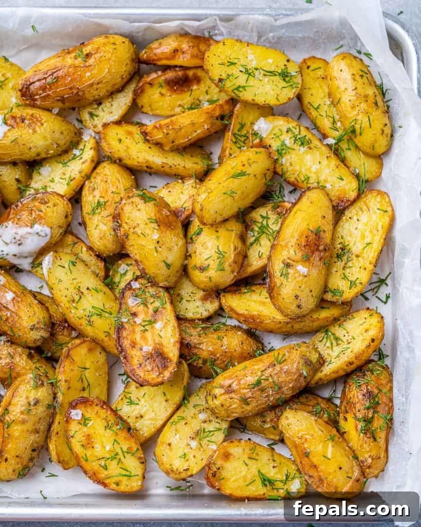 Lemon Herb Greek Baked Fingerlings 7 Crispy baked potato wedges on a parchment lined baking sheet.