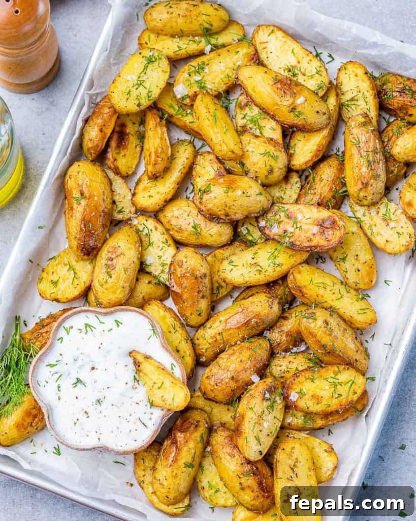 Lemon Herb Greek Baked Fingerlings 10 top view of crispy potato wedges on a pan with greek dressing dip