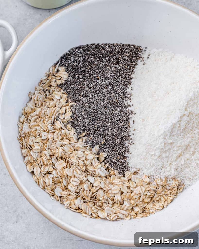 Coconut Cream Pie Dream Oats 4 Adding oats, chia seeds and coconut to a white mixing bowl.