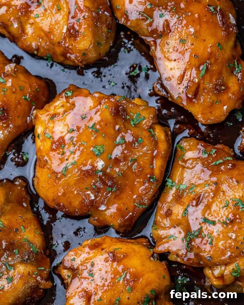 The Ultimate Chicken Adobo 11 Freshly cooked Chicken Adobo, garnished with vibrant green parsley, served in an elegant black pan.