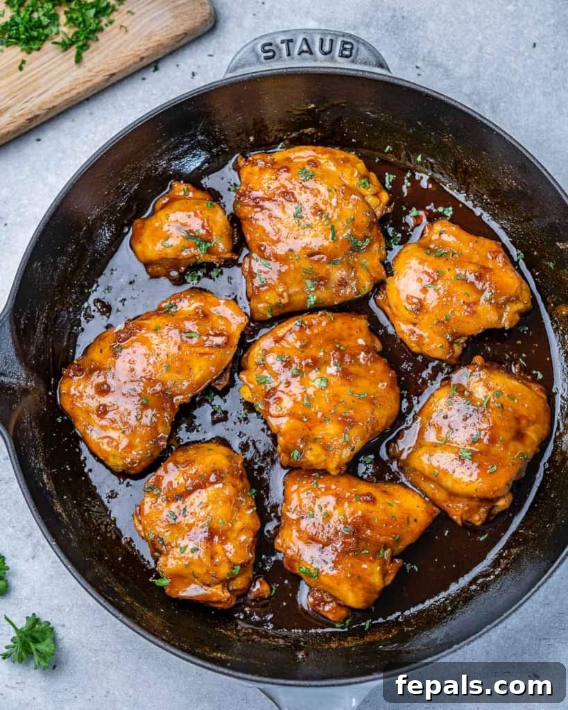 The Ultimate Chicken Adobo 8 Top-down view of glistening adobo chicken thighs simmering in a black skillet, ready to be served.
