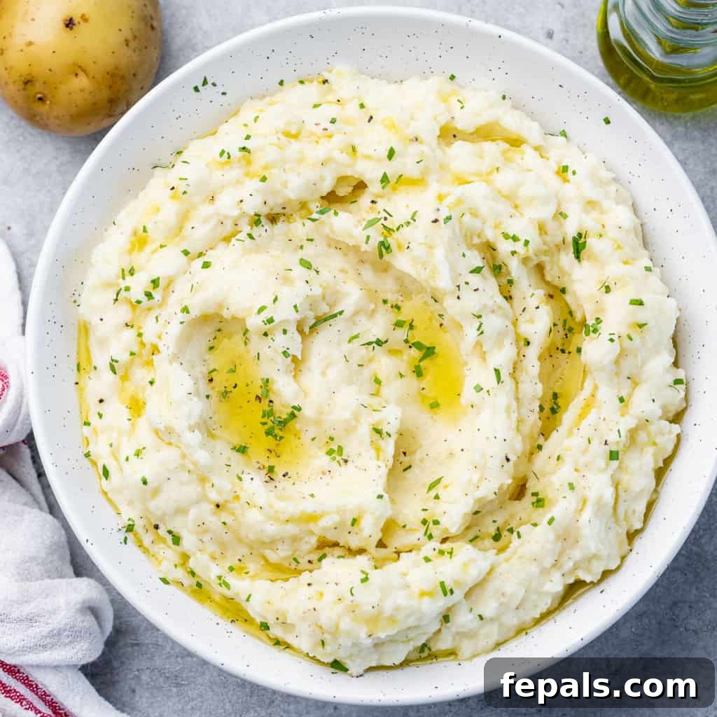 top view mash potato on a white round plate, garnished with fresh herbs